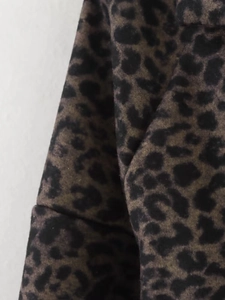 Detailed macro view of the soft leopard print blend fabric texture on the coat