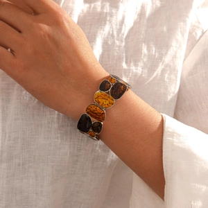 Macro detail of amber resin stretch bracelet on model with warm sunlight texture
