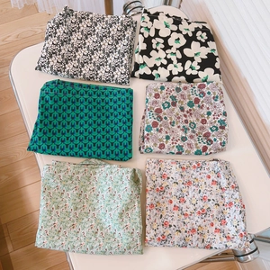 Flat lay of six floral printed cotton tote bags in green and vintage patterns