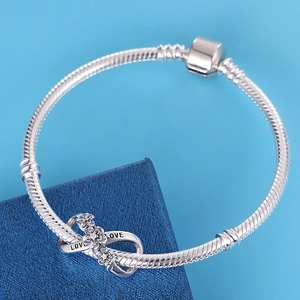 Silver snake chain bracelet featuring an infinity heart charm with diamonds and LOVE engraving