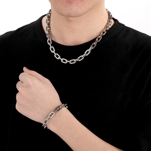 Polished silver stainless steel chain necklace and bracelet set worn by a male model