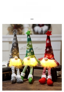 Close-up of three glowing Christmas gnomes with LED lights and snowflake knit hats