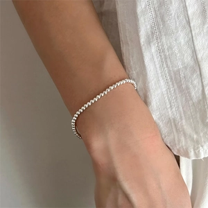 Minimalist 925 sterling silver beaded bracelet with polished metallic finish on wrist