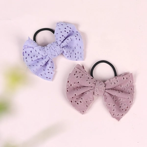 Detail of lavender and dusty pink bow hair ties with hollow embroidery and elastic band