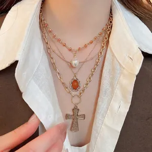 Layered gold cross necklace with acrylic pearls and crystal pendant for women
