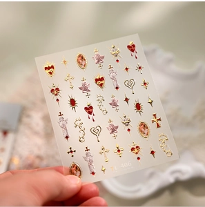 Macro detail of TL-406 nail decals featuring gold embossed sacred heart and angel designs