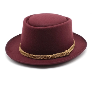 Detail of burgundy wool fedora hat featuring a brown braided rope band and a textured finish