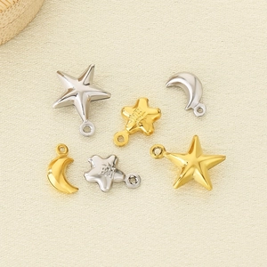 DIY stainless steel gold star and silver moon charms on a soft beige textured surface