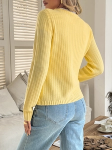 Detail view of the yellow knitted sweater back texture and round neck design