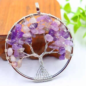 Macro shot of silver wire tree of life pendant with purple crystal stone leaves