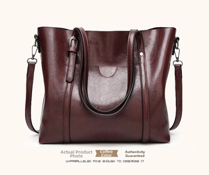 Macro shot of dark coffee leather texture and premium stitching on large tote bag