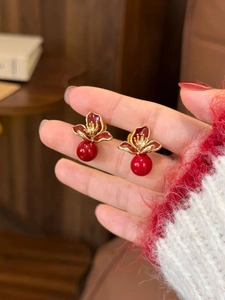 Détail des boucles d'oreilles fleurs en émail rouge rétro avec bordure dorée