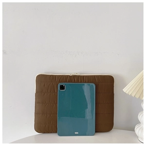 Detail of dark brown quilted laptop sleeve with soft texture and minimalist home decor style
