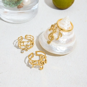 Detailed close-up of 18K gold-plated musical note rings with zircon and hollow line design