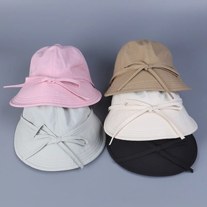 Flat lay of nylon sun hats for women in five colors featuring back ribbon bow details