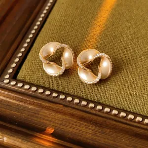 Exquisite gold spiral earrings with inlaid diamonds on a green velvet background