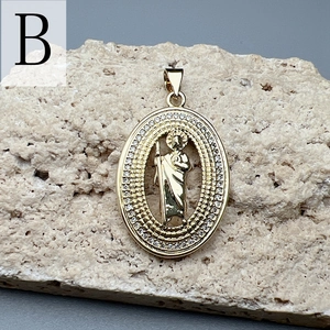 Macro detail of gold oval St. Jude pendant with double-row cubic zirconia settings