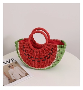 Dettaglio ravvicinato di una borsa in paglia a forma di anguria con interno rosso