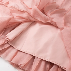 Close-up of soft pink wrinkled chiffon fabric with smooth lining and delicate stitching