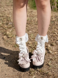 Detail of white lace Lolita socks with pearls and bows paired with pink platform shoes