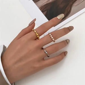 Detail von drei stapelbaren Edelstahl-Spin-Ringen in Gold, Roségold und Silber für Damen