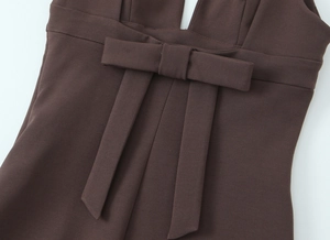 Close-up of the dark brown slim dress showing the ribbon bow detail on the waistline