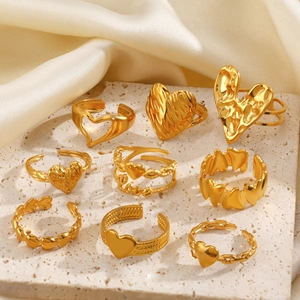 Minimalistische goldene Herzringe aus Edelstahl auf Stein und Samt im Vintage-Stil