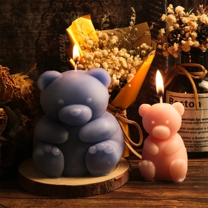Handmade bear scented candles in blue and pink on wooden base with rustic decor