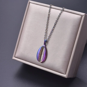 Macro detail of a colorful shell pendant in a beige jewelry box with 18k gold chain