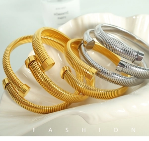 Macro shot of minimalist spiral texture open bracelets in gold and silver finish