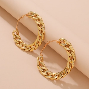 Détail des boucles d'oreilles créoles à gros maillons dorés avec finition métallique