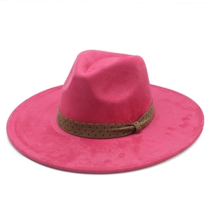 Détail d'un chapeau fedora rose rouge avec ruban à pois marrons et décoration nœud