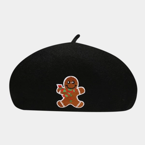 Detail of embroidered gingerbread man on black wool blend beret for Christmas fashion