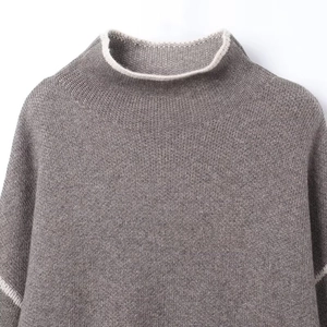 Detailed close-up of grey knit sweater neck with contrast cream stripes and soft texture