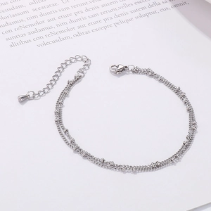 Detail view of a double-layered stainless steel bead chain bracelet with lobster clasp