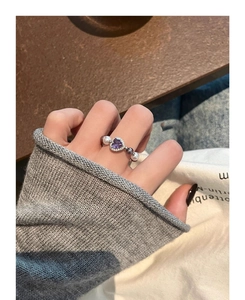 Elegant silver ring with purple heart zircon and pearls shown on a model's hand
