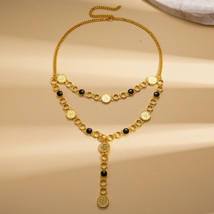 Detail of vintage gold layered necklace featuring black beads and embossed coin pendants