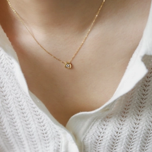 Close-up of minimalist 18K gold plated titanium necklace with hexagonal diamond pendant
