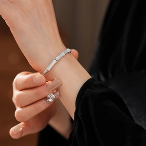 Detailed view of a silver bamboo joint bracelet with mother-of-pearl inlay on a model