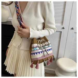 Close-up of bohemian brown bucket bag with colorful woven patterns and tassel details