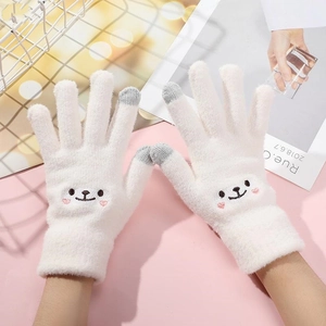 Close-up of white knitted gloves with touch screen fingertips and a cute bear design