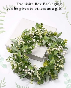 Detailed eucalyptus and berry wreath shown with its elegant square gift box packaging