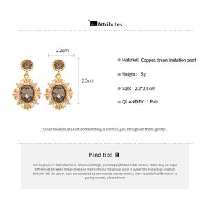 Detail view of retro gold-plated oval earrings with brown zircon and imitation pearls