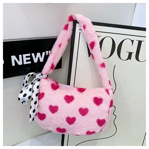 Detailed close-up of pink faux fur plush bag with red hearts and polka dot ribbon