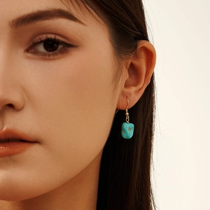 Elegant S925 silver turquoise drop earrings with gold hooks on a model closeup