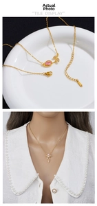 Detail of gold stainless steel necklace with pink rose and bow pendant on model