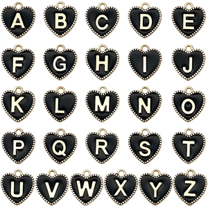 Macro shot of 26 heart-shaped alloy alphabet charms with gold plating and black enamel