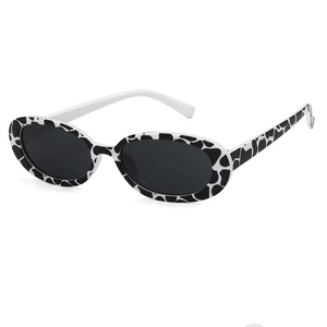 Oval cow print sunglasses with black lenses and asymmetric white and spotted temples