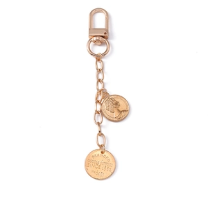 Golden keychain with lobster clasp and round coin pendants featuring a queen portrait