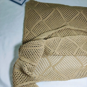 Close-up of khaki knitted tote bag showing intricate geometric hollow weave pattern
